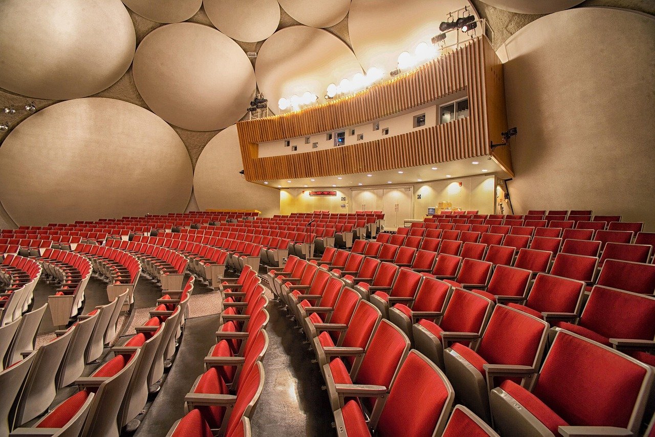 Auditório com difusores acústicos no teto — projeto acústico integrado à arquitetura