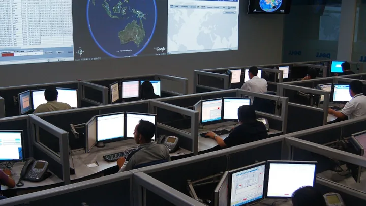 Centro de operações real com videowall, mapas globais e fileiras de operadores