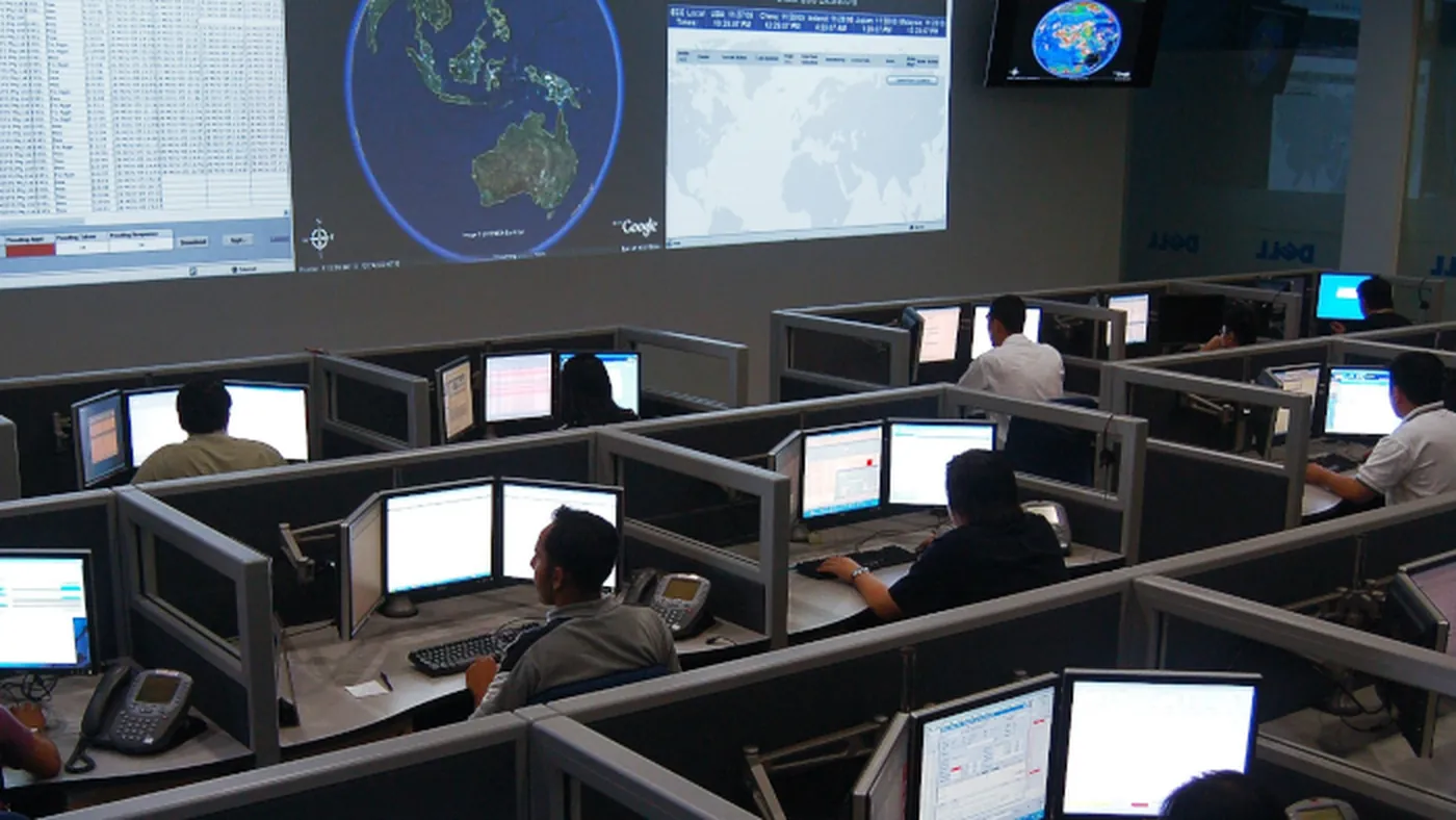 Centro de operações real com videowall de monitoramento global e fileiras de operadores