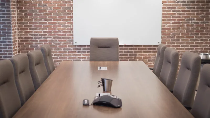 Sala de reunião com tela de projeção e cadeiras voltadas para a imagem