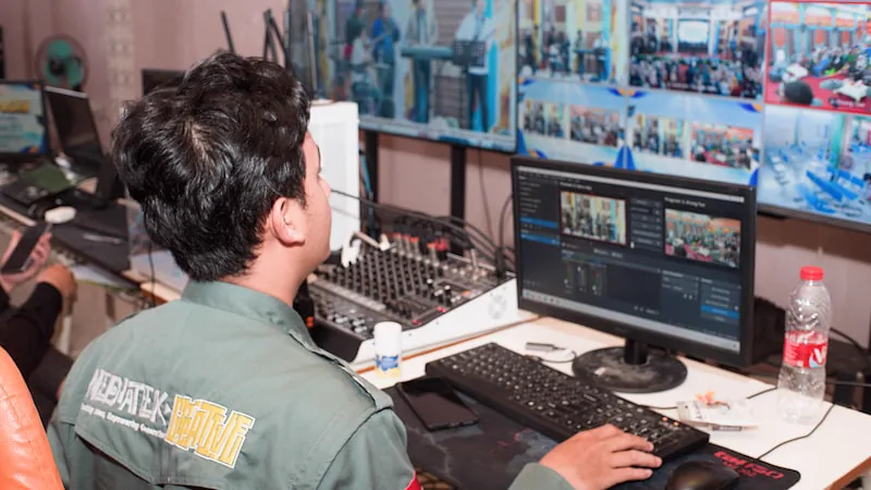 Operador uniformizado manuseando equipamentos de vídeo e áudio