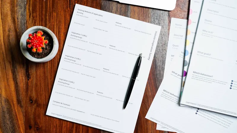 Mesa de trabalho com documentos impressos e caneta