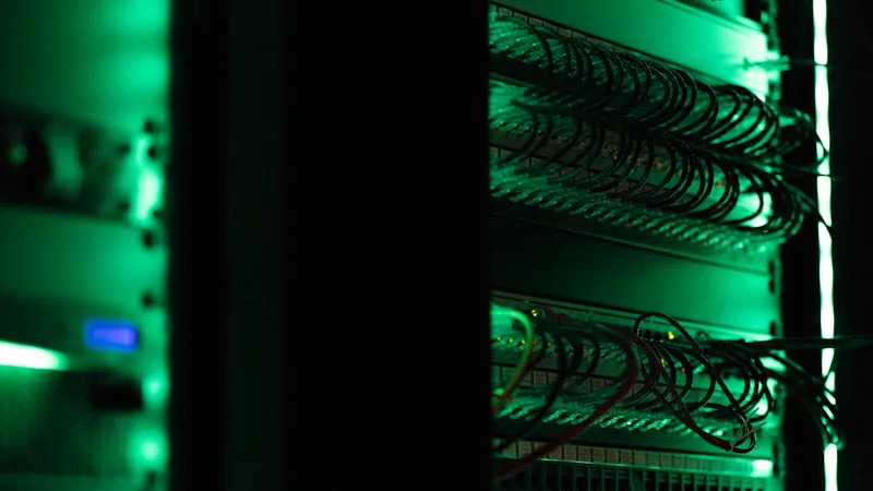 Rack de equipamentos eletrônicos em sala de datacenter com pouca luz